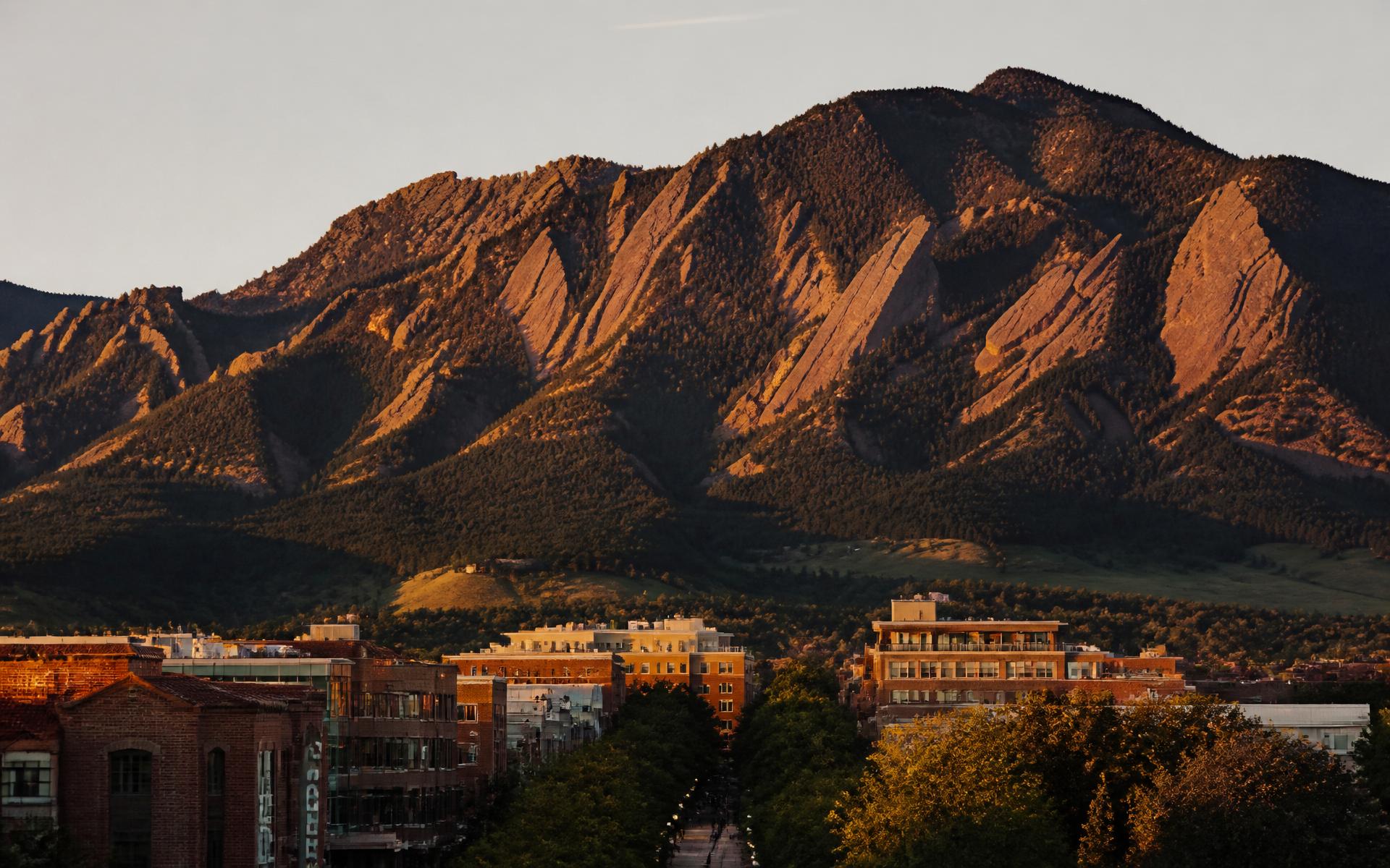 The Flatirons rising above downtown Boulder, Colorado at golden hour